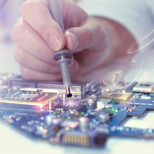 close-up of masculine hand soldering a circuit board